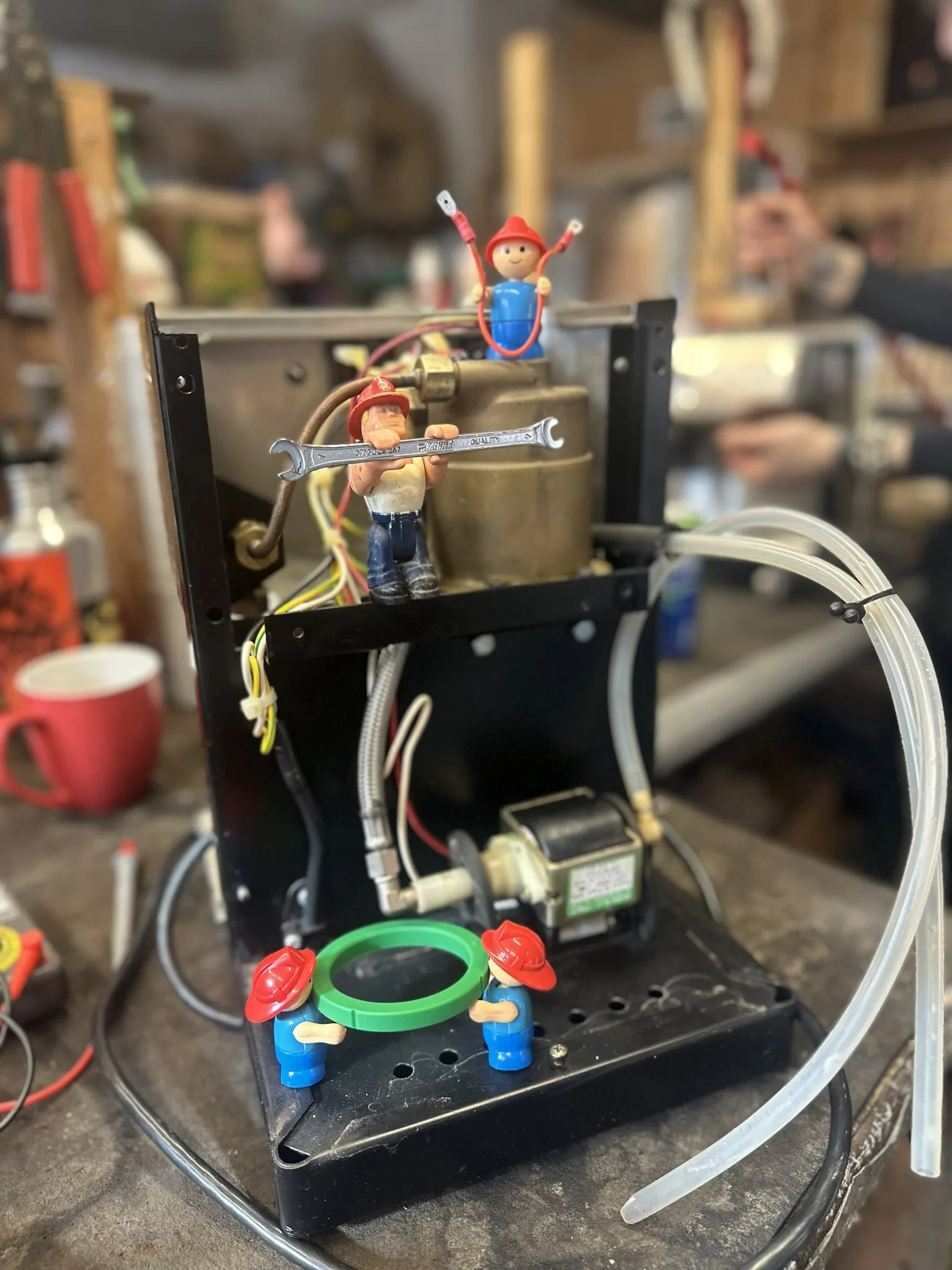 Toy mechanics working on an open espresso machine